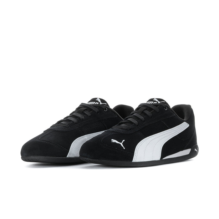 Women's black low-top sneakers with white stripe and PUMA logo, side view