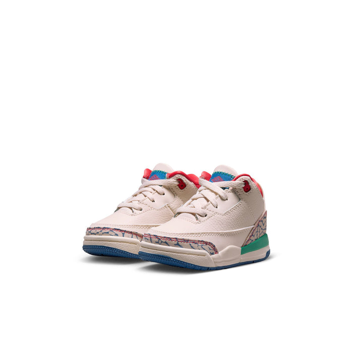 Toddler low-top sneaker angled view in cream with red collar and multicolor side panel
