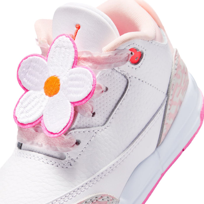 Toddler sneaker with flower lace charm, pink accents, and white upper