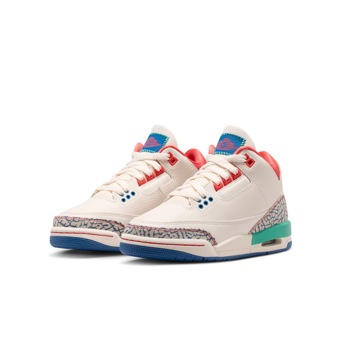 Youth sneakers angled view with white uppers, red collar, blue lace eyelets, teal sole
