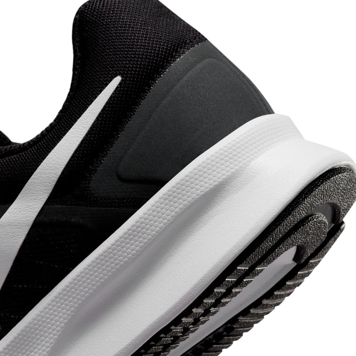 Black side view close-up with white midsole panel and textured rubber outsole edge.