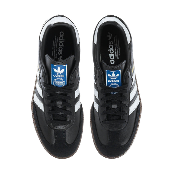 Black adidas Samba OG sneakers with blue adidas tongue label and white side stripes.