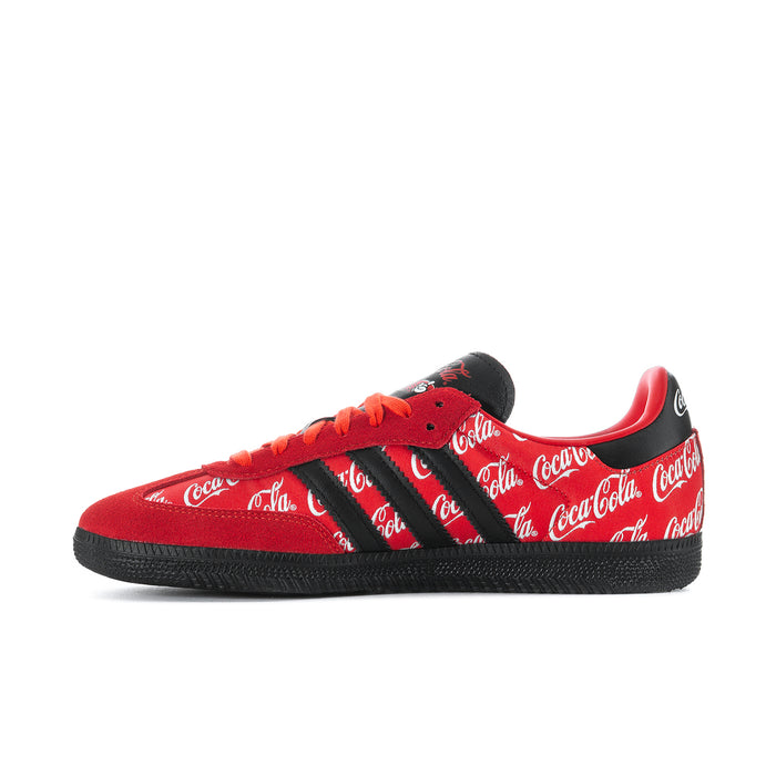 Red and black low-top sneakers with Coca-Cola script, black stripes, and orange laces