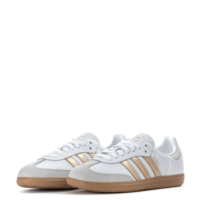 Pair of women's adidas Samba OG low-top sneakers in white with metallic gold stripes, gum sole
