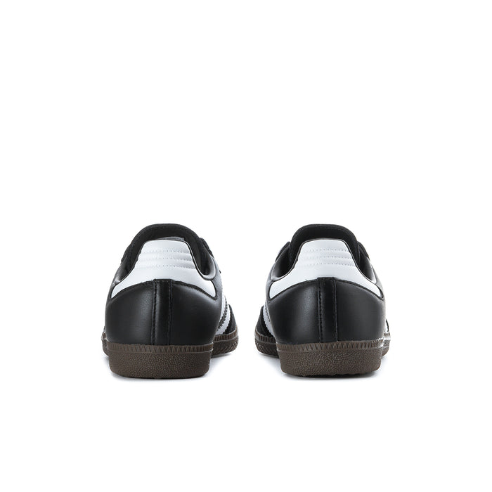 Black adidas sneakers with white heel detail and brown gum outsole, rear view