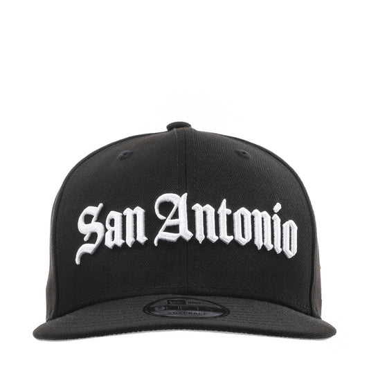 Black baseball cap with white "San Antonio" script logo on front, flat brim