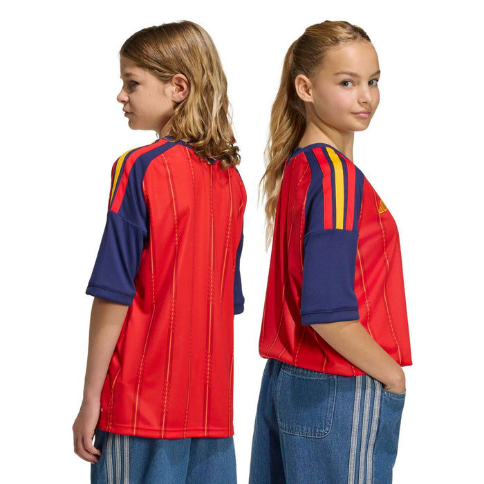 Youth football jersey in vivid red with navy sleeves and yellow shoulder stripes