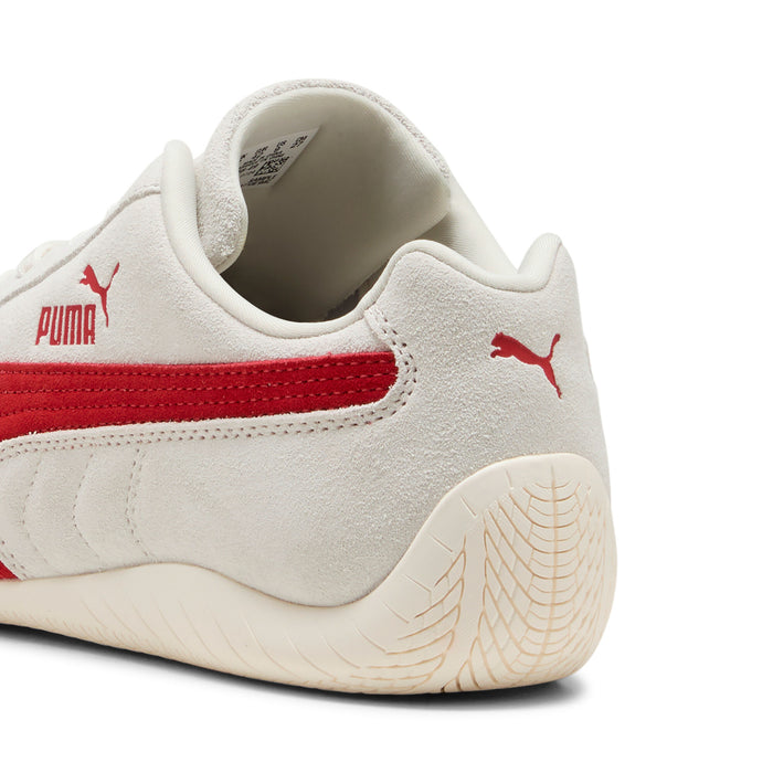 Women's Puma sneaker heel close-up; off-white suede with red stripe and textured sole