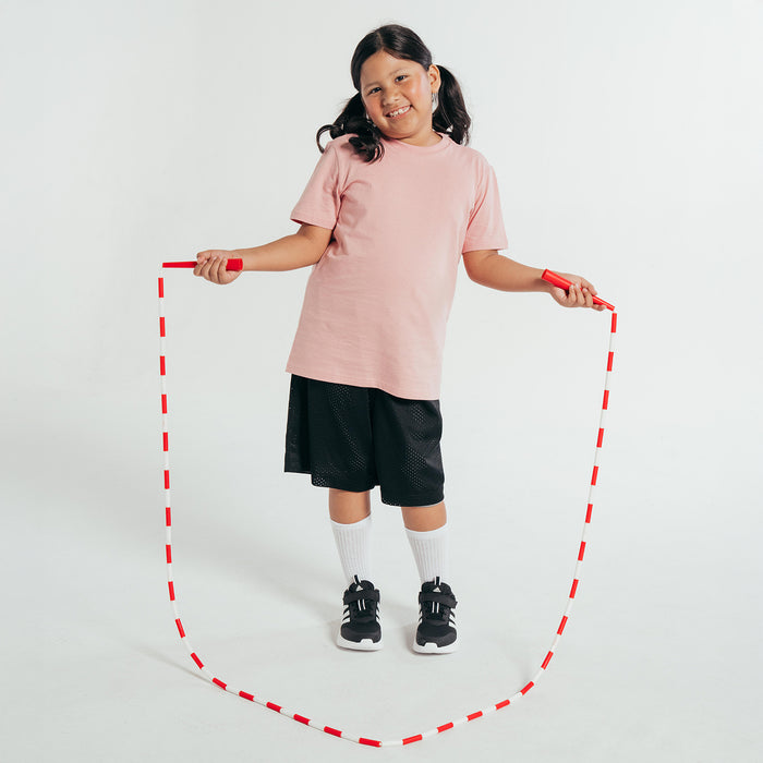 Pink youth crew-neck T-shirt with short sleeves, worn with dark shorts.