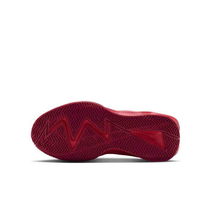Youth basketball shoe outsole with dark patterned tread on red rubber