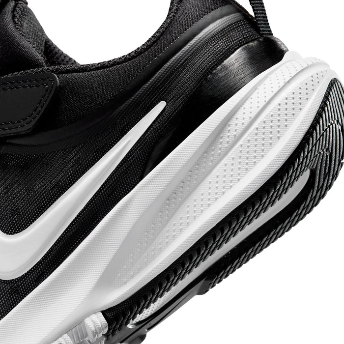 Kids black sneaker close-up of midsole and tread with white swoosh accents