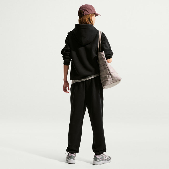 Youth black fleece loose pants in back view with cuffed hems and Nike logo