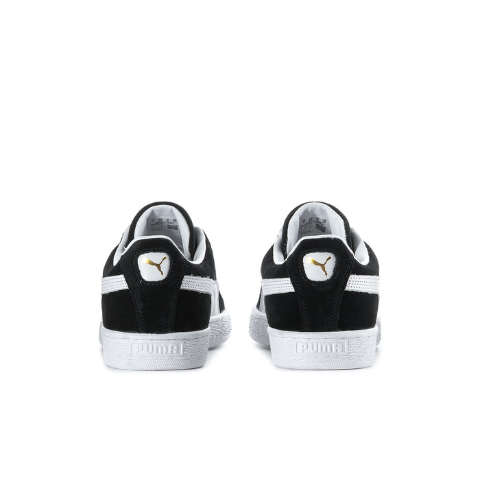 Black suede sneakers, back view with Puma logo heel tab and white sole