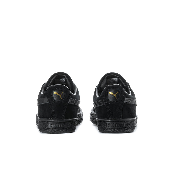 Black suede sneakers heel view with Puma logo on heel tab.