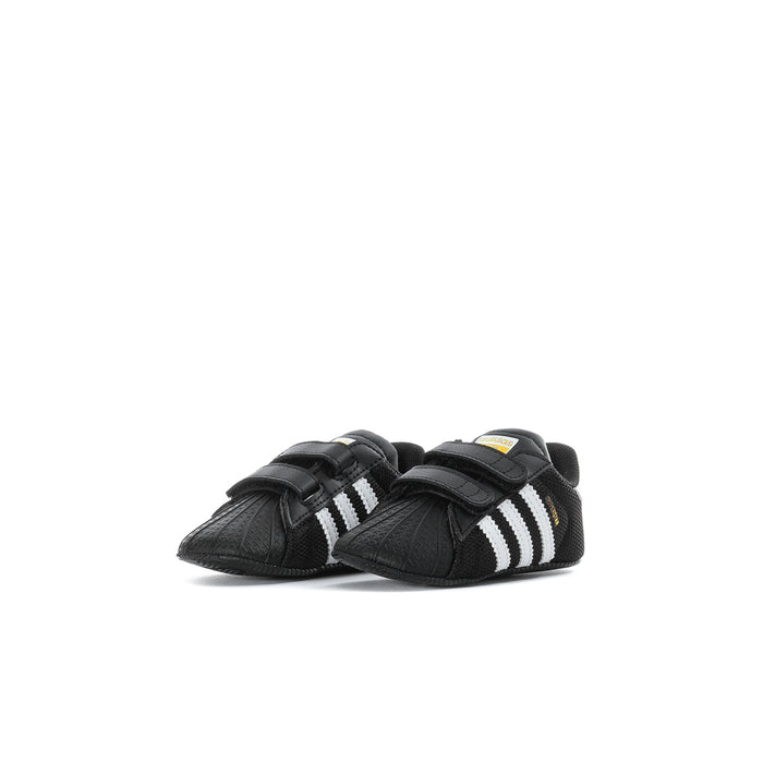 Infant black adidas Superstar sneakers shown from side with double Velcro straps