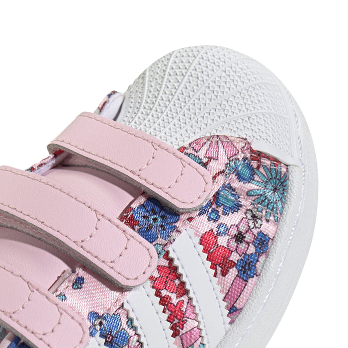 Close-up of kids' sneaker straps and floral fabric with white textured sole