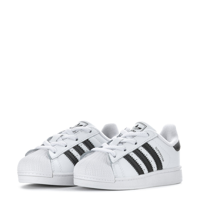 Pair of toddler white sneakers with black stripes and white laces