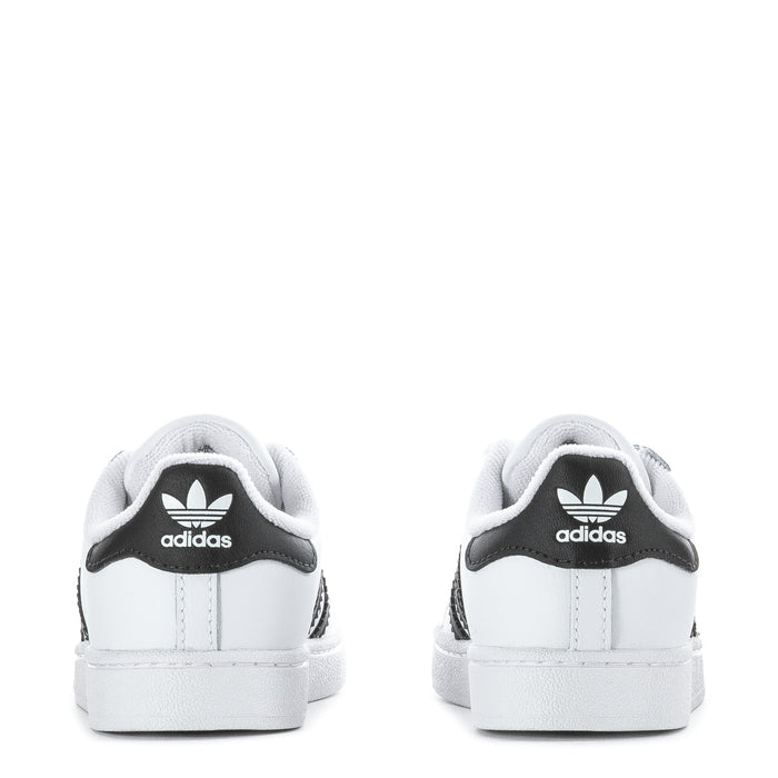 Toddler white sneakers with black adidas logo on the heel