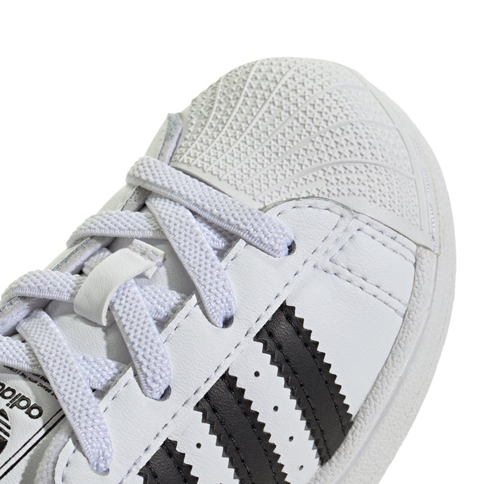 Toddler sneaker close-up of white leather upper, laces, and black stripe detail
