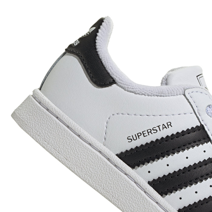 Toddler white sneaker side view with black collar panel and rubber sole