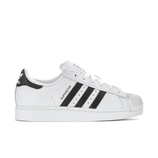 Women's low-top sneakers in white with black three-stripe details, lace-up design