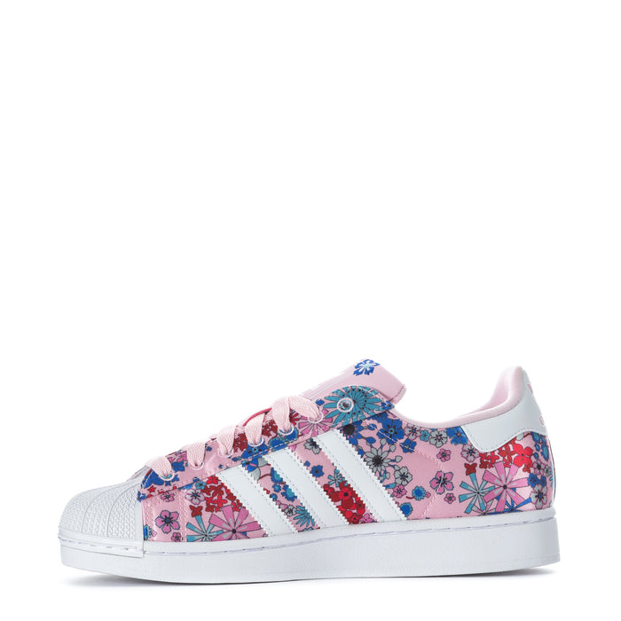 Youth floral low-top sneaker, pink patterned upper with white stripes and laces.
