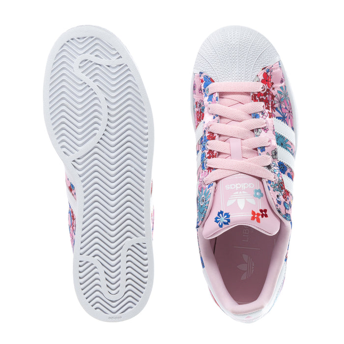Youth sneaker soles shown: white tread and pink floral upper with lace-up closure.