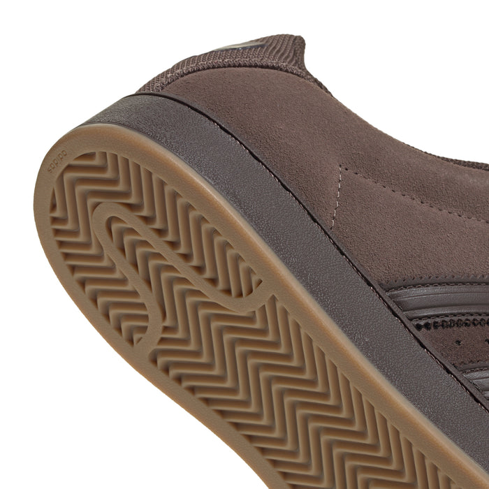 Brown rubber outsole close-up with herringbone tread and suede sidewall