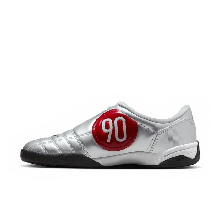 Metallic silver sneaker with round red 90 patch and black rubber sole.