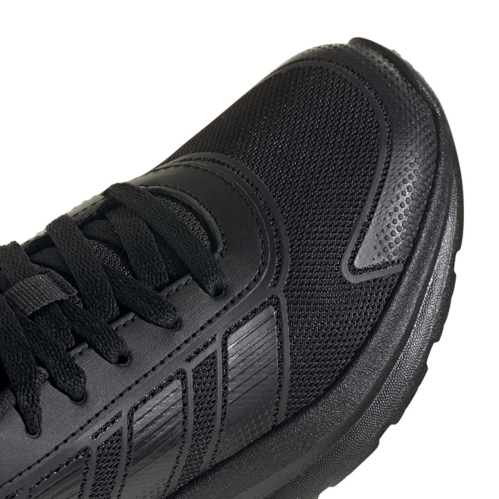 Close-up of youth black running shoe upper with lace eyelets and textured knit