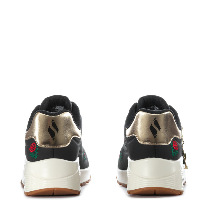 Black low-top sneaker with white sole, metallic heel, rose and green leaf embroidery