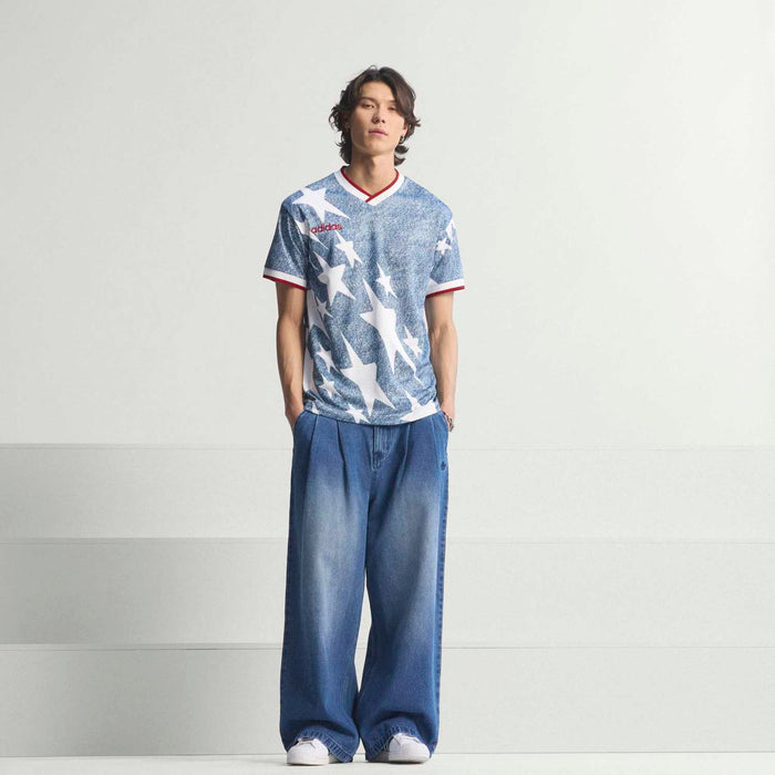 Men's denim star print jersey with red-and-white V-neck trim, worn with blue jeans