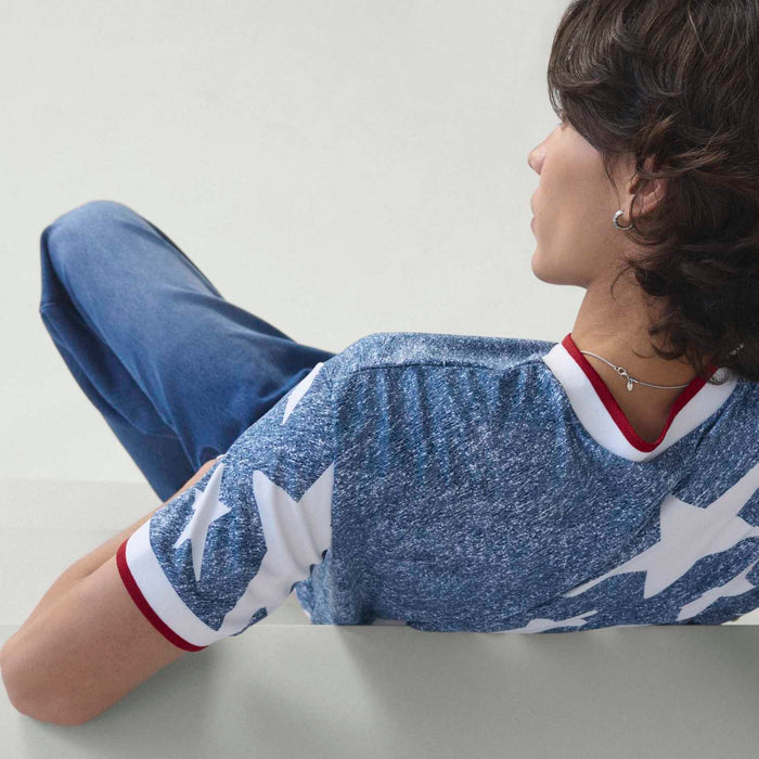 Men's denim jersey with white star graphic and red-and-white V-neck trim, side view