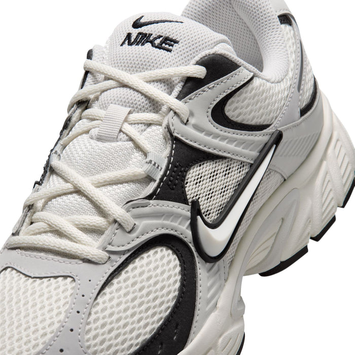 Men's running shoe close-up, light gray mesh upper with black swoosh and off-white laces