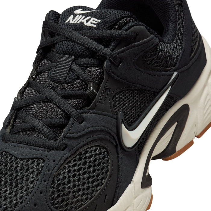 Black womens sneakers close-up with laces, Nike swoosh and textured mesh panels