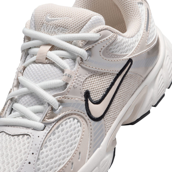 Youth white sneaker close-up, lace-up mesh upper with black swoosh logo