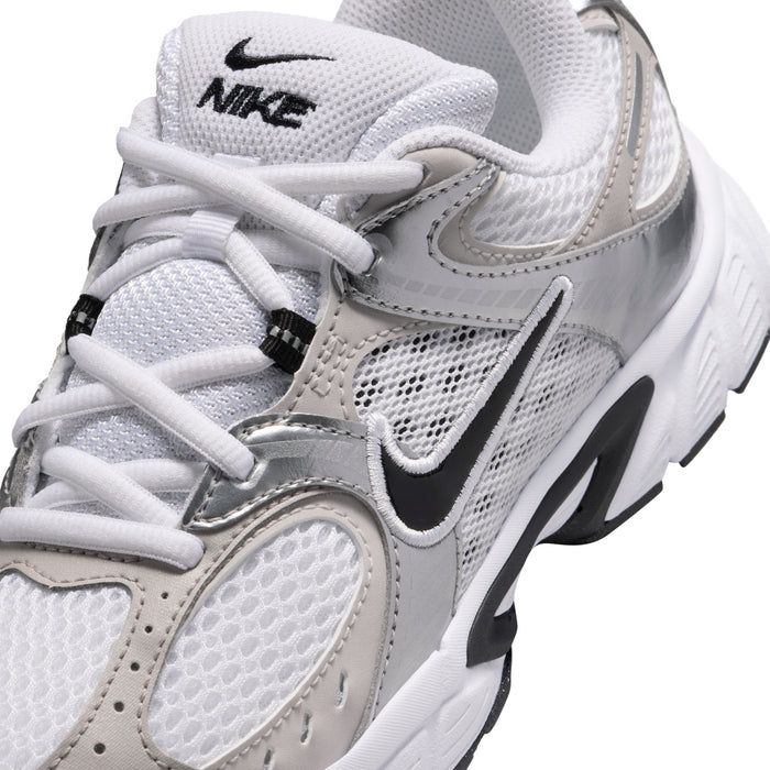 Close-up of youth sneaker upper: white and light gray mesh with black Nike swoosh