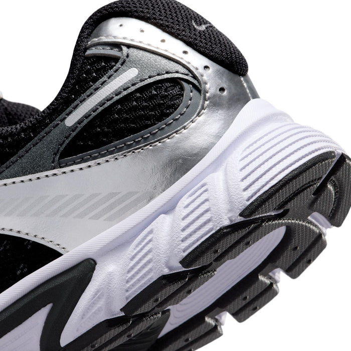 Nike youth shoe close-up of silver side panel and white sole with traction grooves
