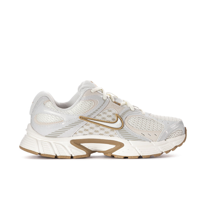 Women’s athletic sneaker in white with tan/gold accents and chunky sole