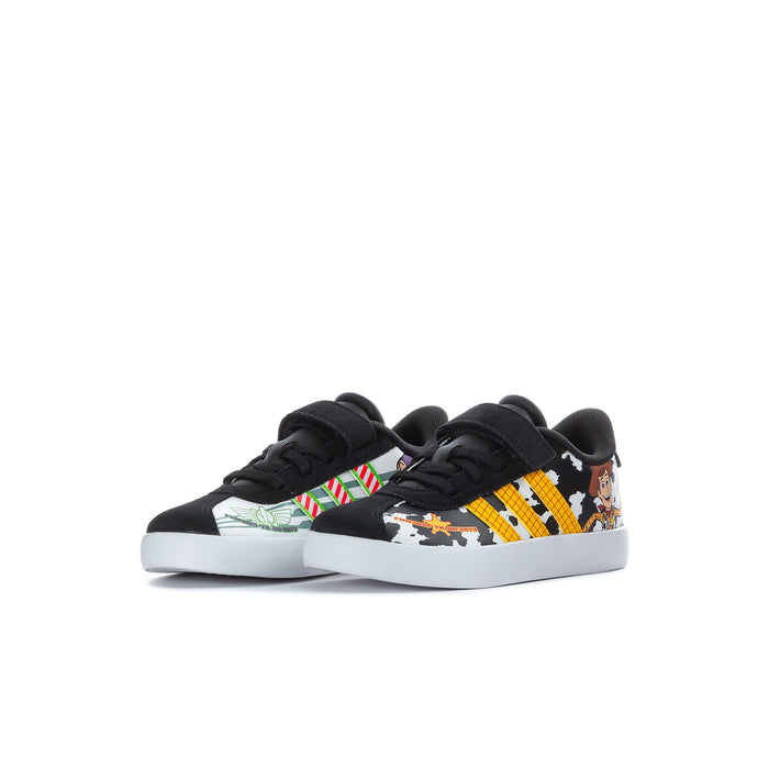 Kids' black sneakers, side view: cow-print, yellow stripes, cartoon character artwork