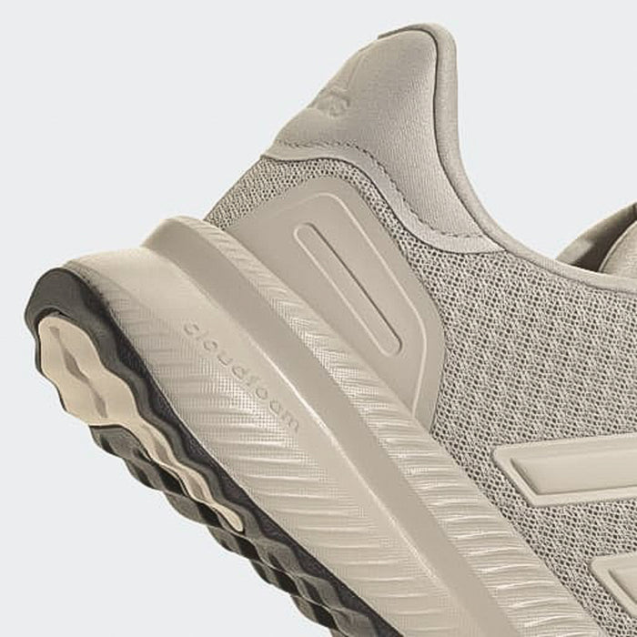 Men's sneaker close-up of side and sole with dark tread pods and light grey upper